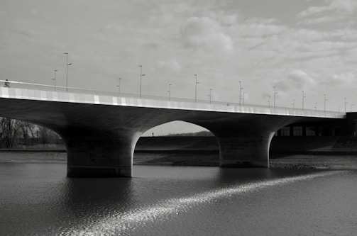 Completed bridge structure showing clean lines and durable concrete, with a river flowing underneath.