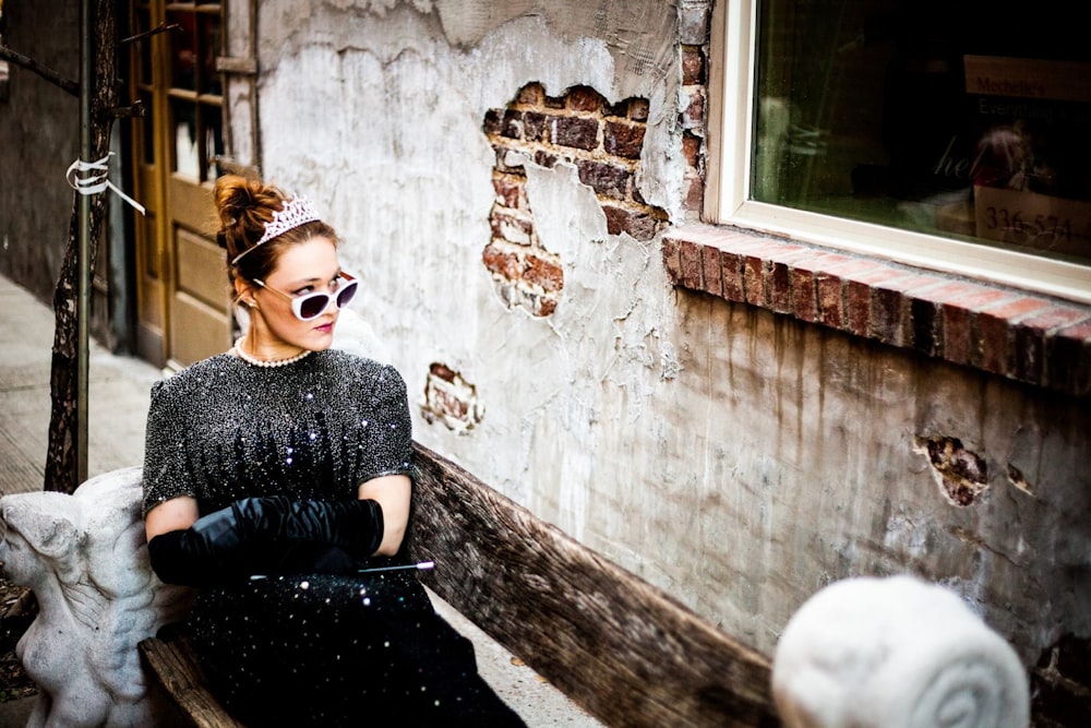 woman sit on bench facing on concrete wall