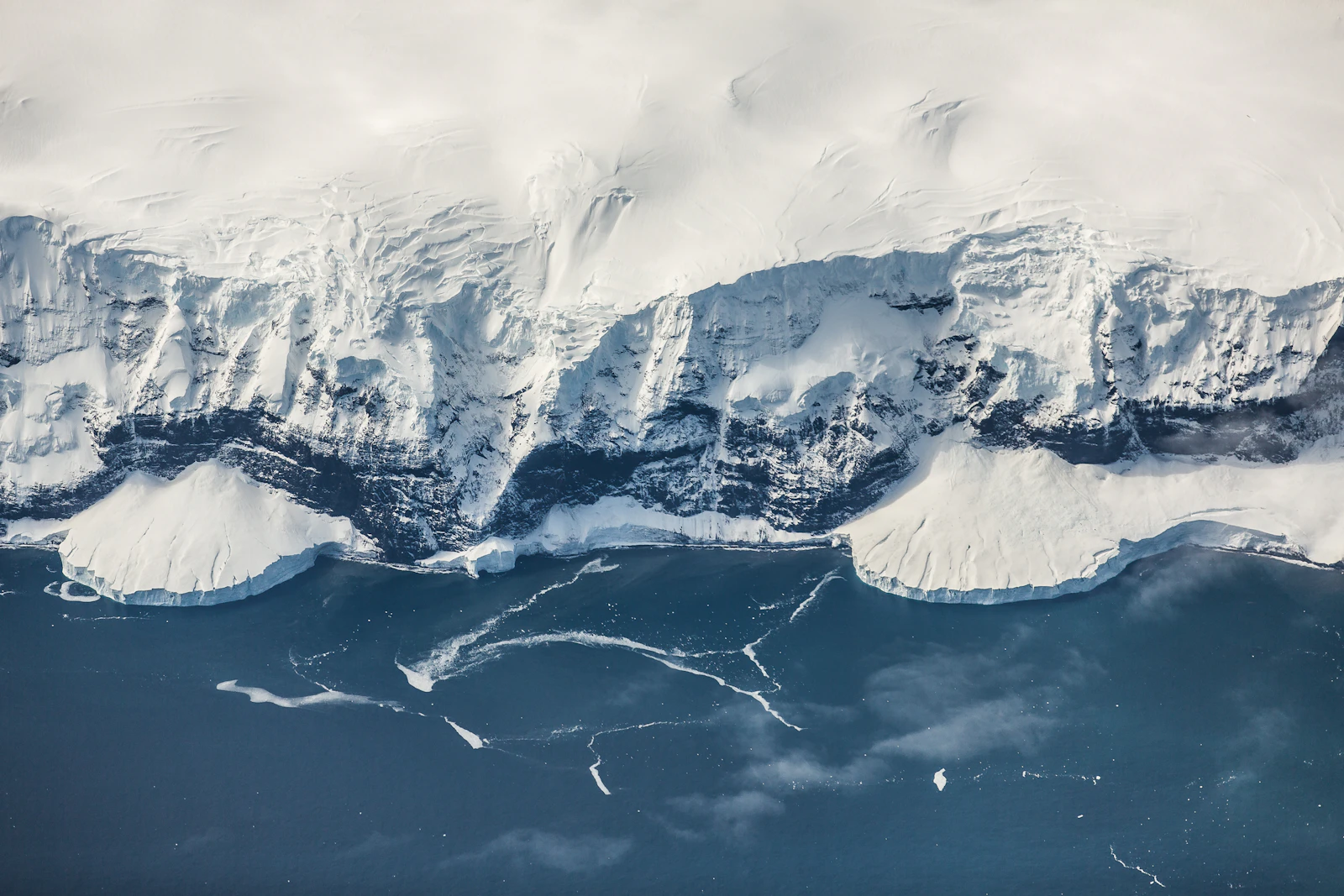 Wind-carved ice and snow stretching to a flat polar horizon