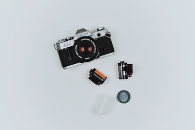 black Canon film camera with two films in flat lay photography