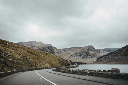 landscape photography of road near mountain under cloudy sky in Wales United Kingdom