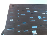 A sleek modern building facade with dark grey and anthracite tones, highlighting natural textures.