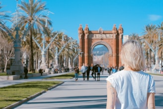woman standing on road near concrete arch at daytime