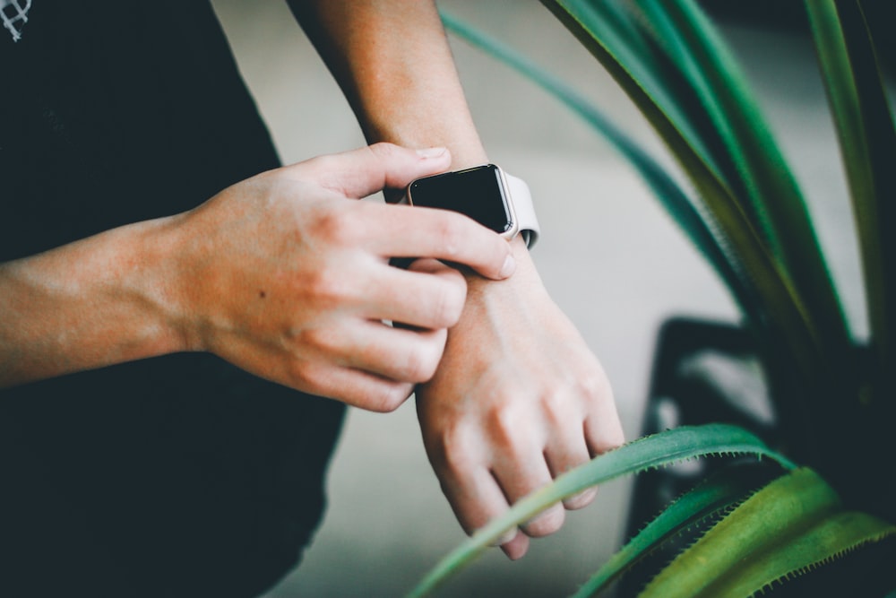 person about to use silver Apple Watch in grey Sports Band