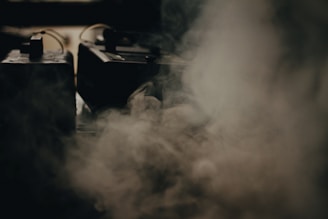 Close-up of the JBI Smart Fog Unit emitting fine mist in a large industrial space.