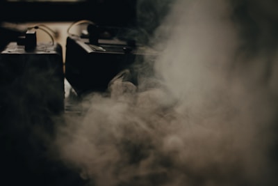 Close-up of the JBI Smart Fog Unit emitting fine mist in a large industrial space.