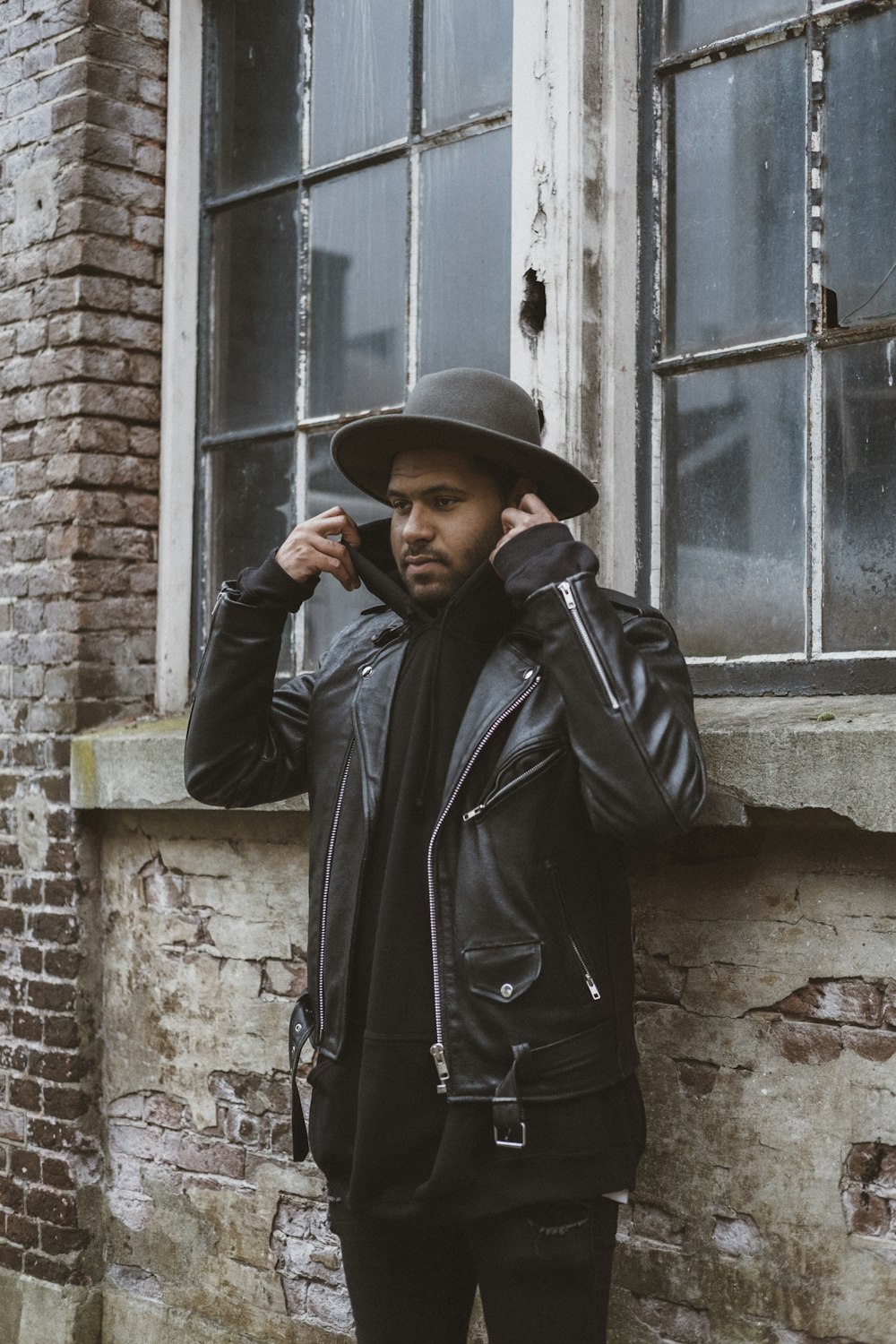 man wearing coat beside a window