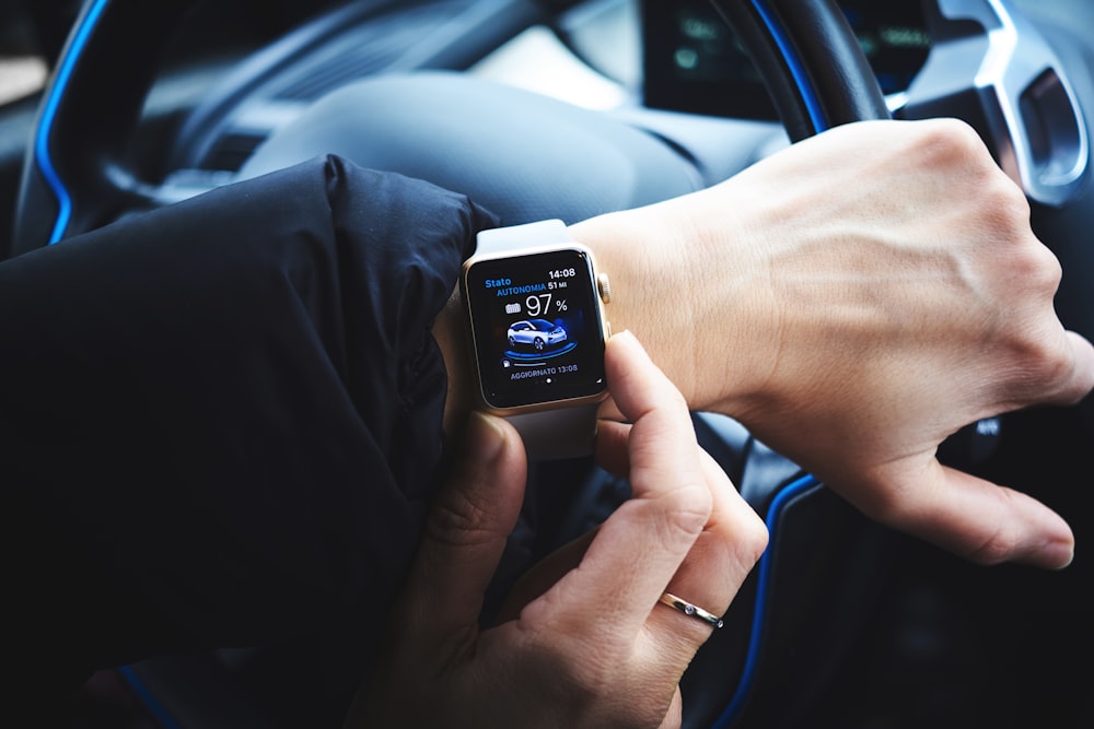 person holding gold aluminum Apple Watch