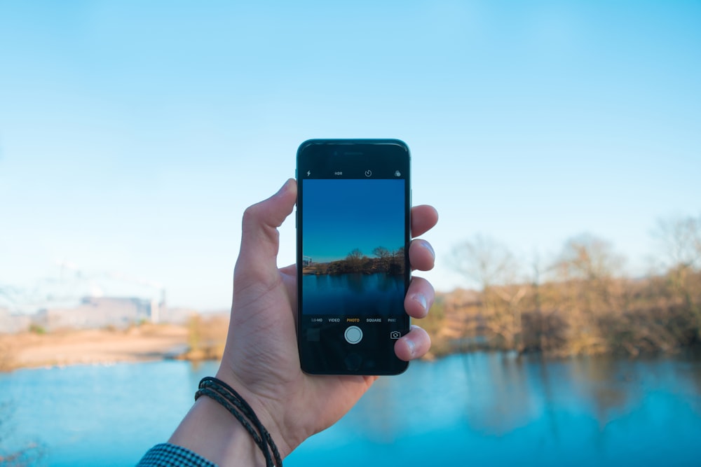 person showing photo of body of water