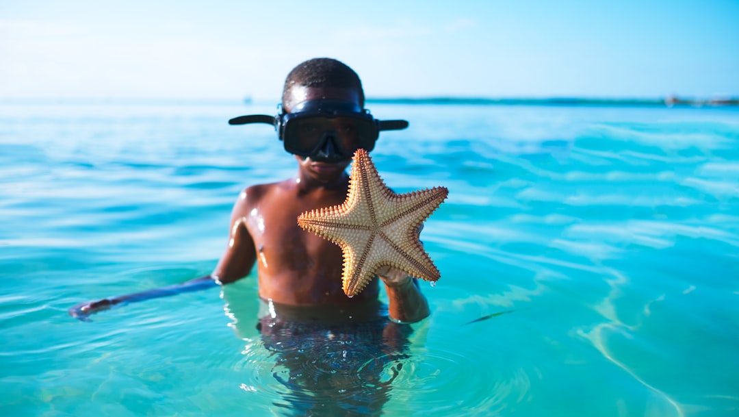 man carrying star fish, Little boy showing us a starfish he caught snorkeling around the island.