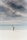 woman looking up to the sky while standing on white sand
