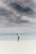 woman looking up to the sky while standing on white sand