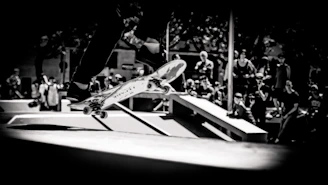 A dynamic shot of a skateboarder mid-air performing a trick in an urban skatepark.