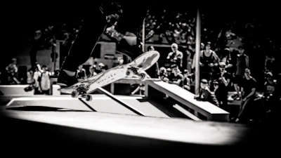 A dynamic shot of a skateboarder mid-air performing a trick in an urban skatepark.