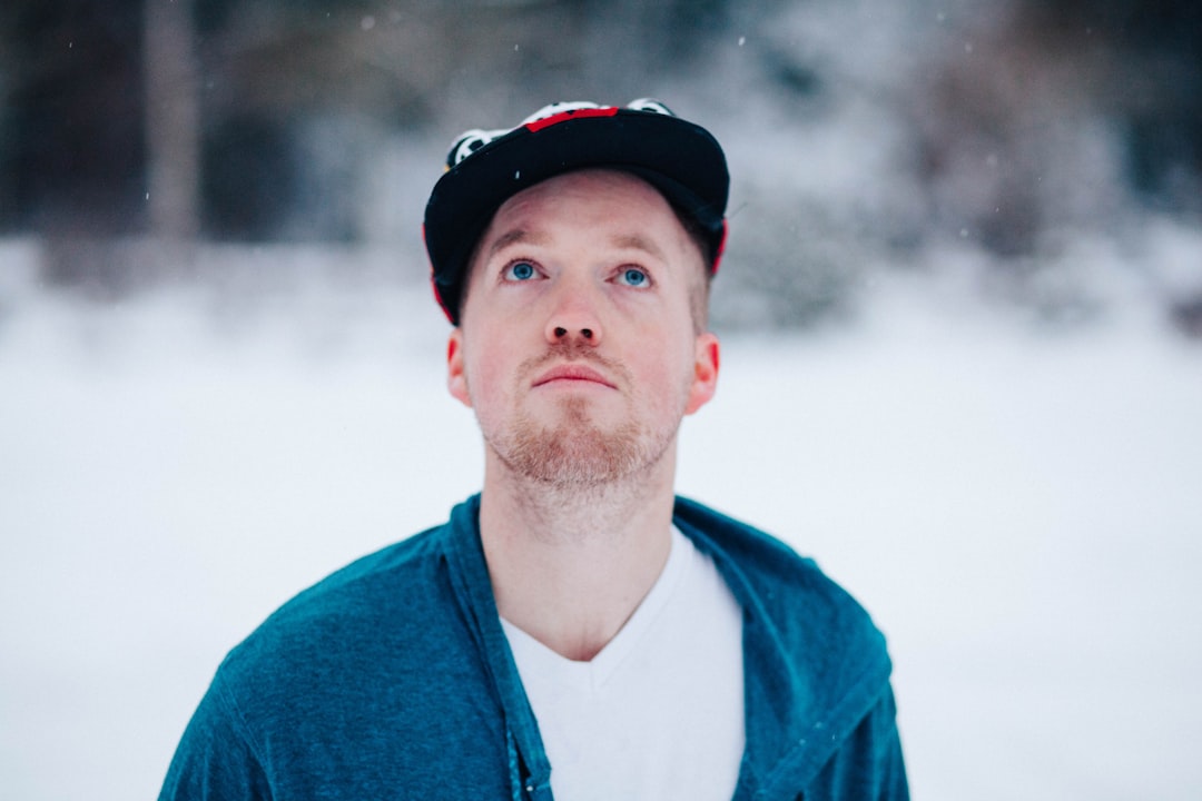 man looking up standing on snow covered ground