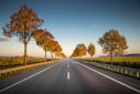 long straight road with trees on the side