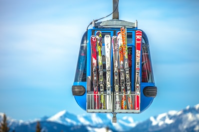 selective focus photography of ski blades on blue cable car