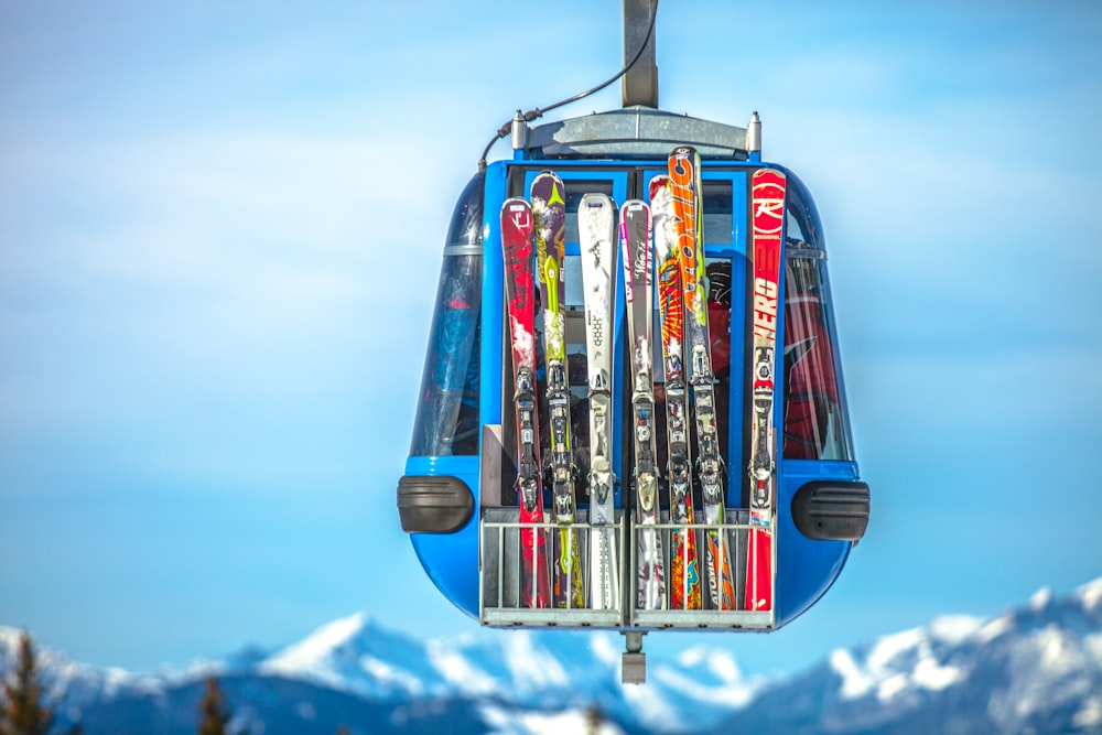 fotografia de foco seletivo de lâminas de esqui em teleférico azul