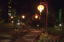 Outdoor lantern illuminating a garden path during twilight hours.