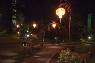 A modern outdoor lantern illuminating a garden pathway