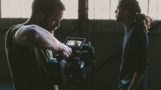 man holding camcorder with man near wall