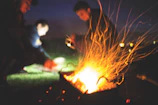 Friends gathered around a fire pit enjoying a lively outdoor barbecue evening.