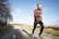 Man running on a forest trail with focused expression