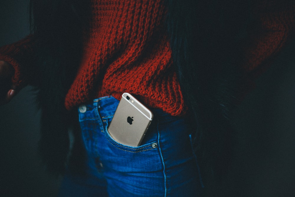 iPhone 6 dourado no bolso da pessoa