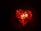 A glowing heart shape formed by embers and flames against a dark background. The heart is outlined in bright red and orange colors, giving it a vibrant and intense appearance.