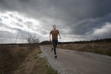 man running at the road during daytime