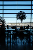 A panoramic view of the lounge overlooking the airport runway through large windows.
