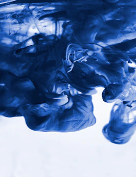 A swirling neon violet ink cloud dissolving into deep black shadows.