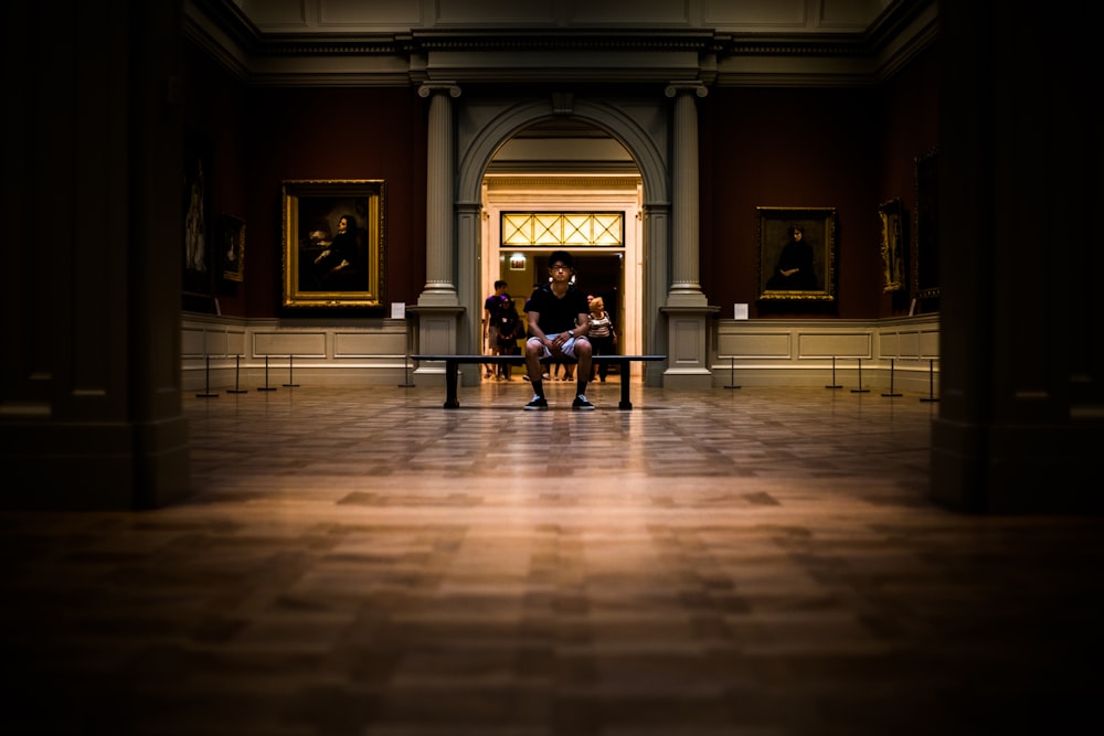 man sitting on bench on middle of house interior