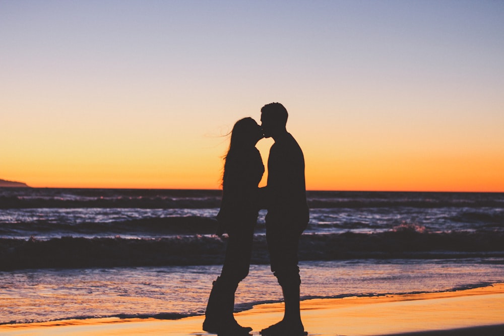 silhouette di coppia seduta in riva al mare
