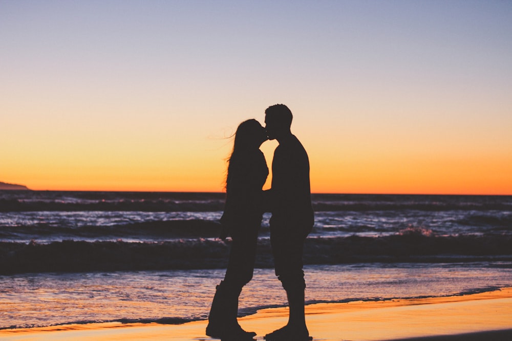 silhouette de couple assis sur le bord de la mer