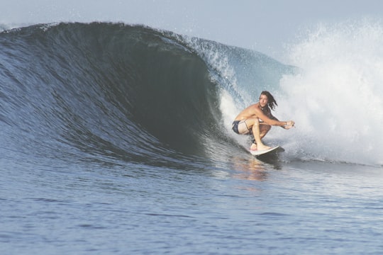 man surfing with big wave in Sumbawa Indonesia