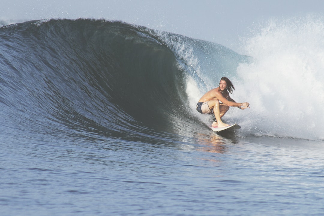 man surfing with big wave, Crouching surfer in action