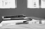 Black and white photograph of Edward M. Bounds writing at a vintage desk surrounded by manuscripts.