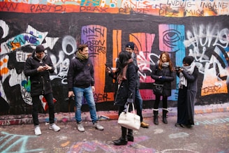 people walking beside painted wall