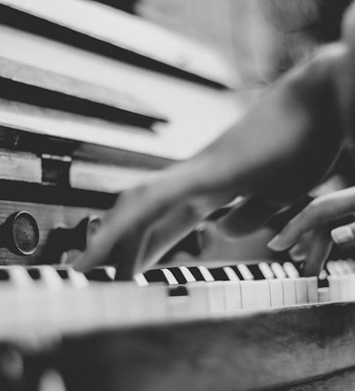 gray scale photo of person playing piano