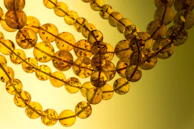 Warm amber beads strung in a delicate pattern, catching light with every curve