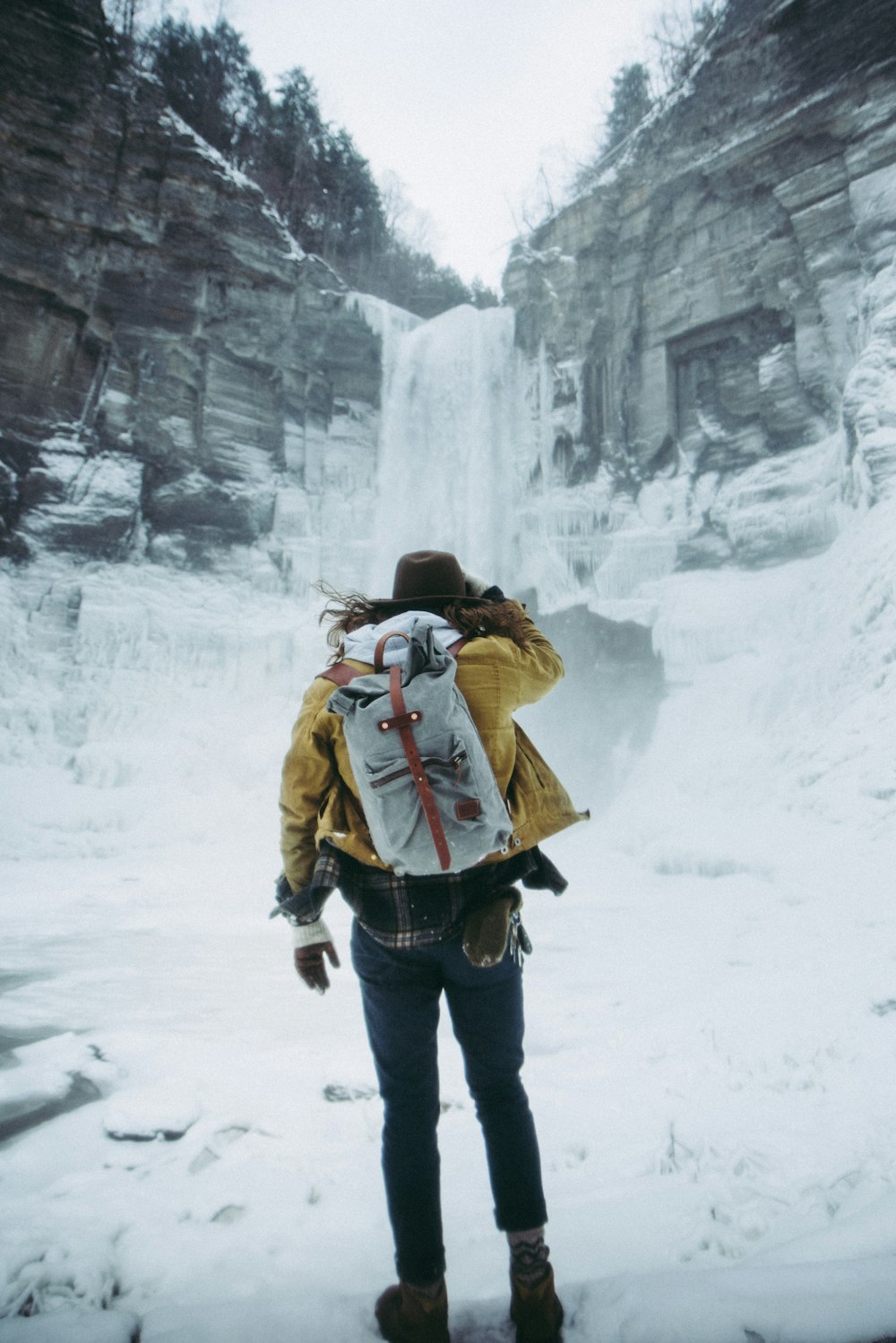 woman facing frozen waterfalls