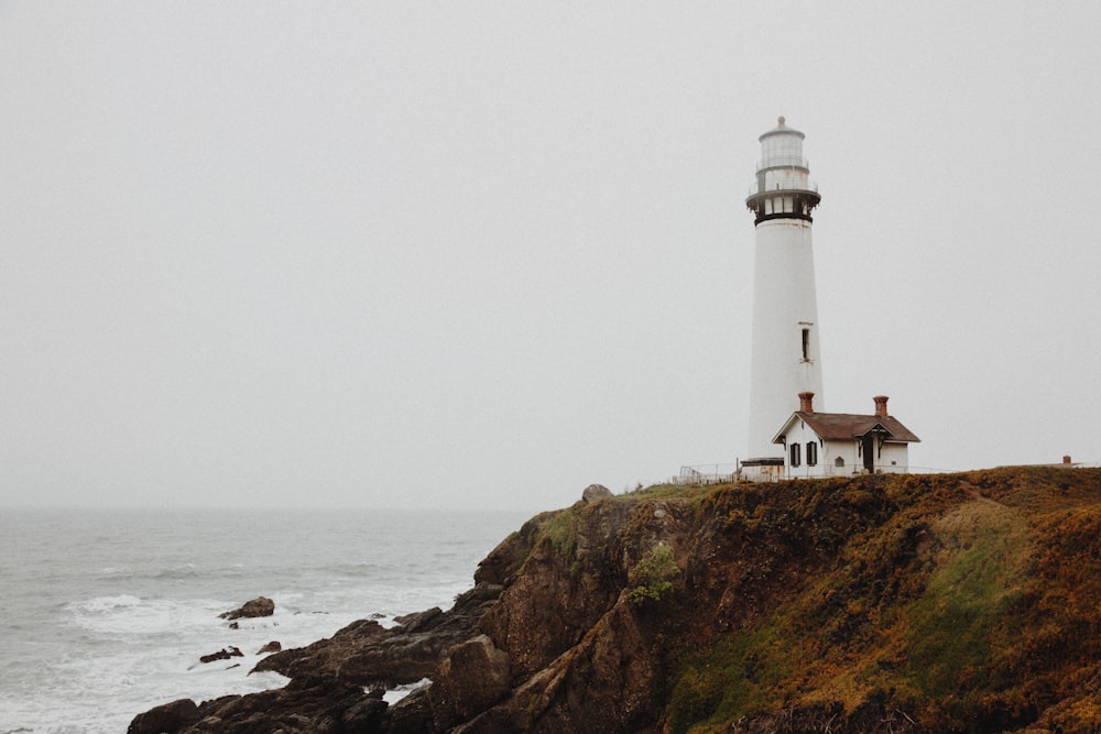 Farol branco no penhasco rochoso