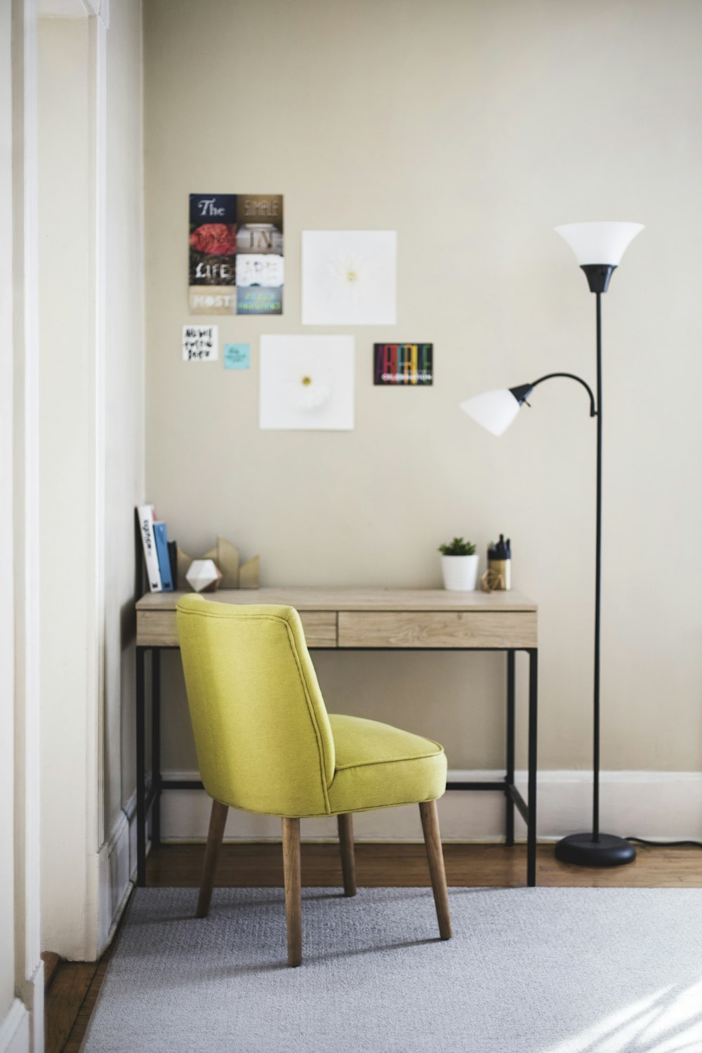 black 2-light torchiere beside brown wooden-top desk with black steel frame