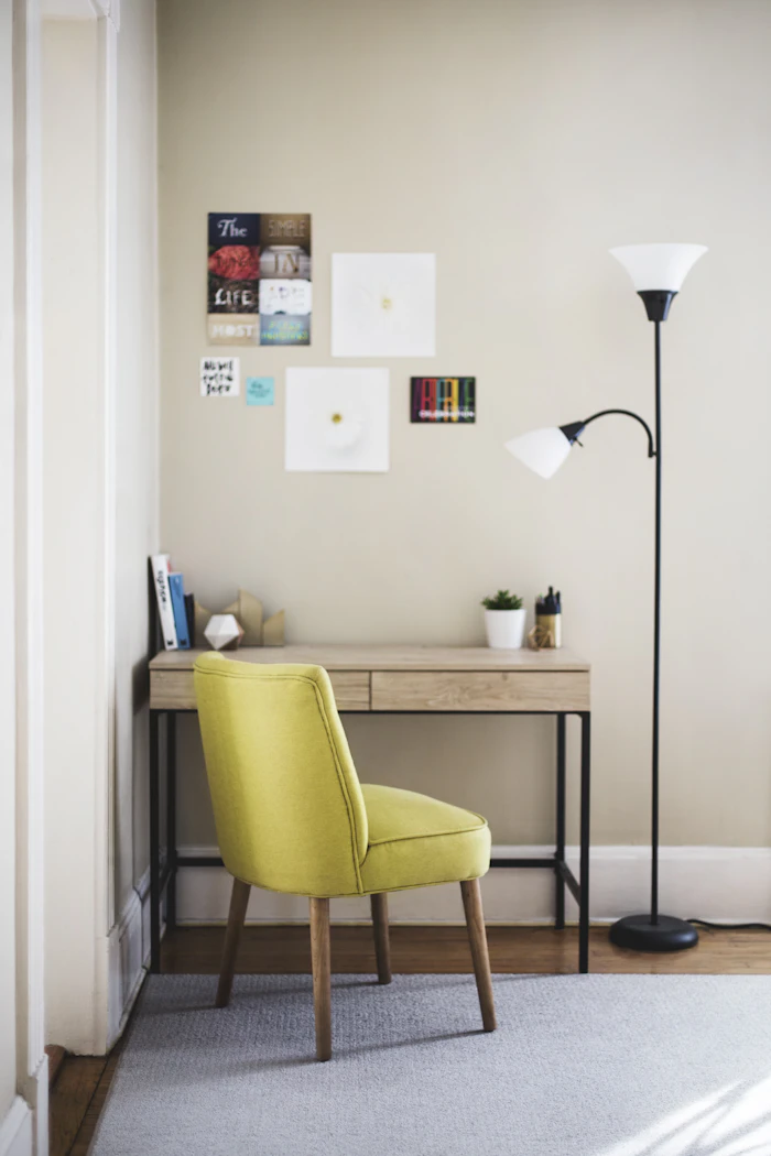 Small writing desk with a mustard upholstered chair and a floor lamp