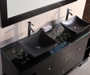 A bathroom vanity topped with a smooth stone countertop and surrounded by elegant cabinetry