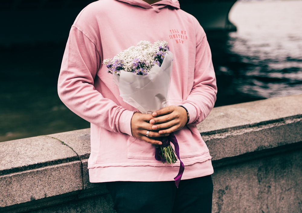 personne tenant un bouquet de fleurs