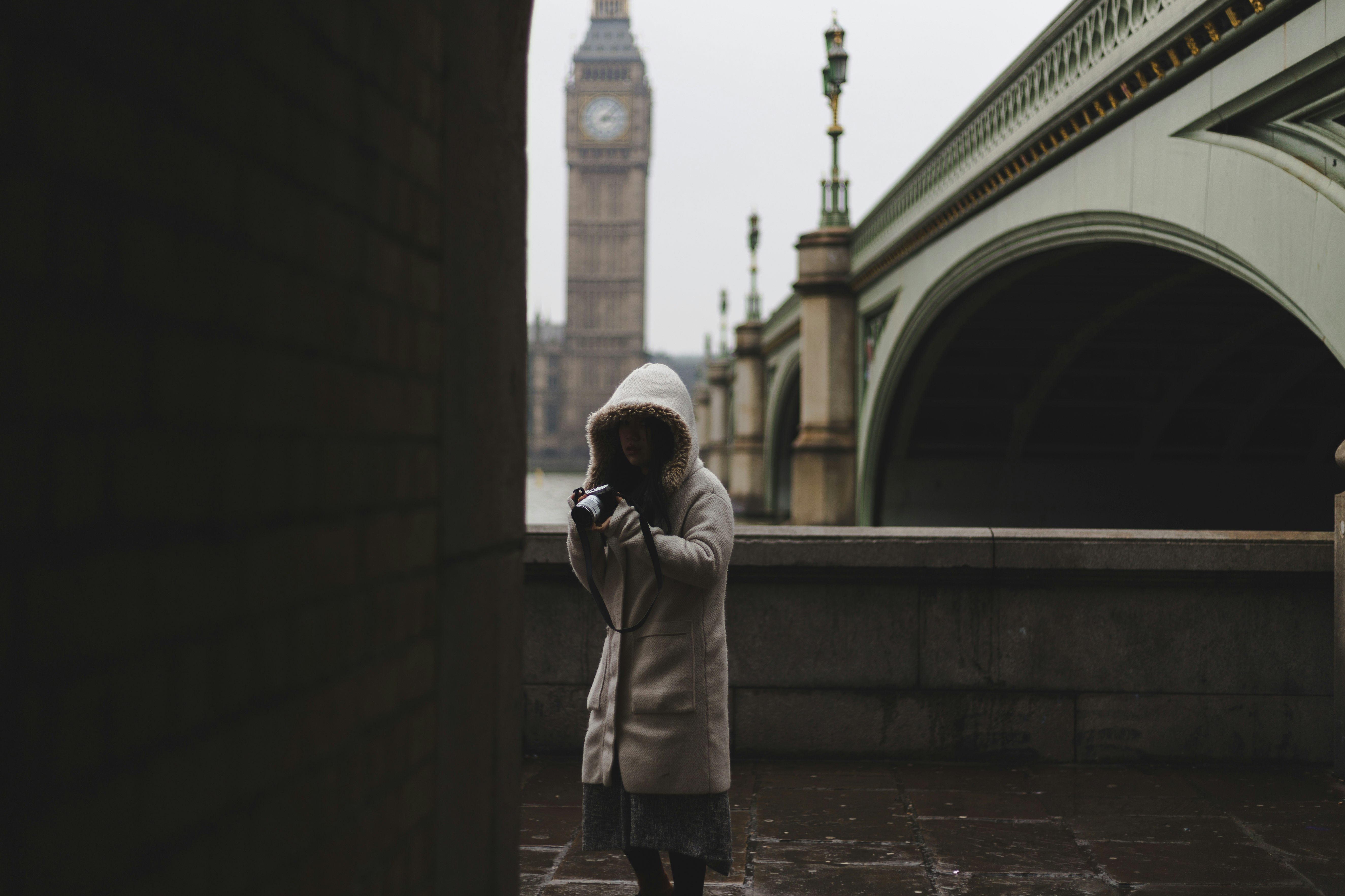 woman standing beside brown wall