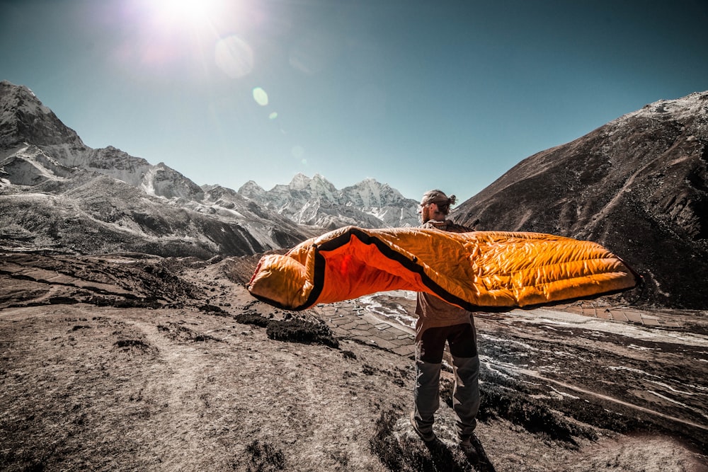 man standing on field between cliffs