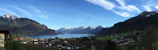 A panoramic view of Tsomgo Lake with a cab waiting nearby for travelers.